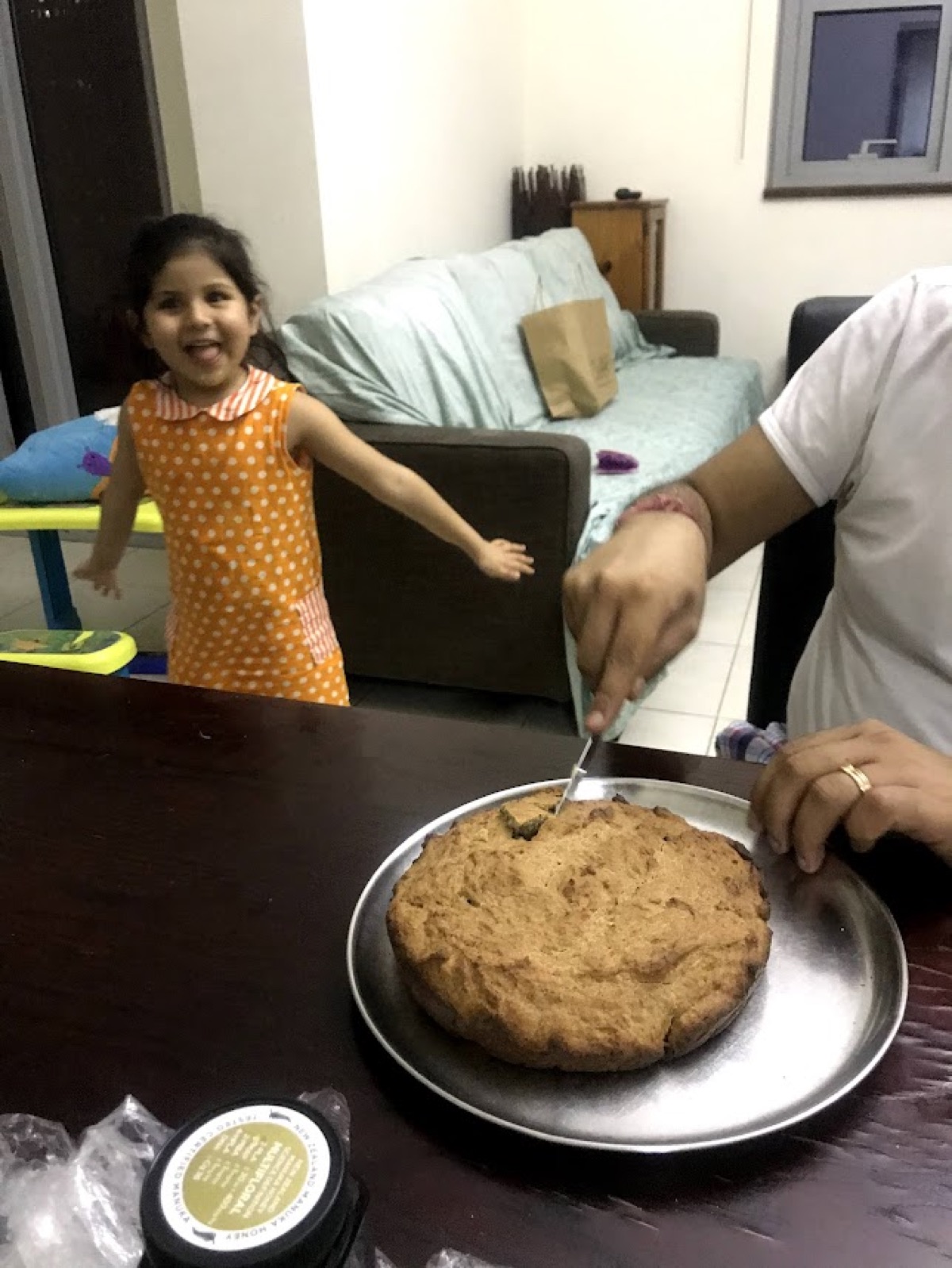 A beaming young Vedhica running up as a cake is served at the table