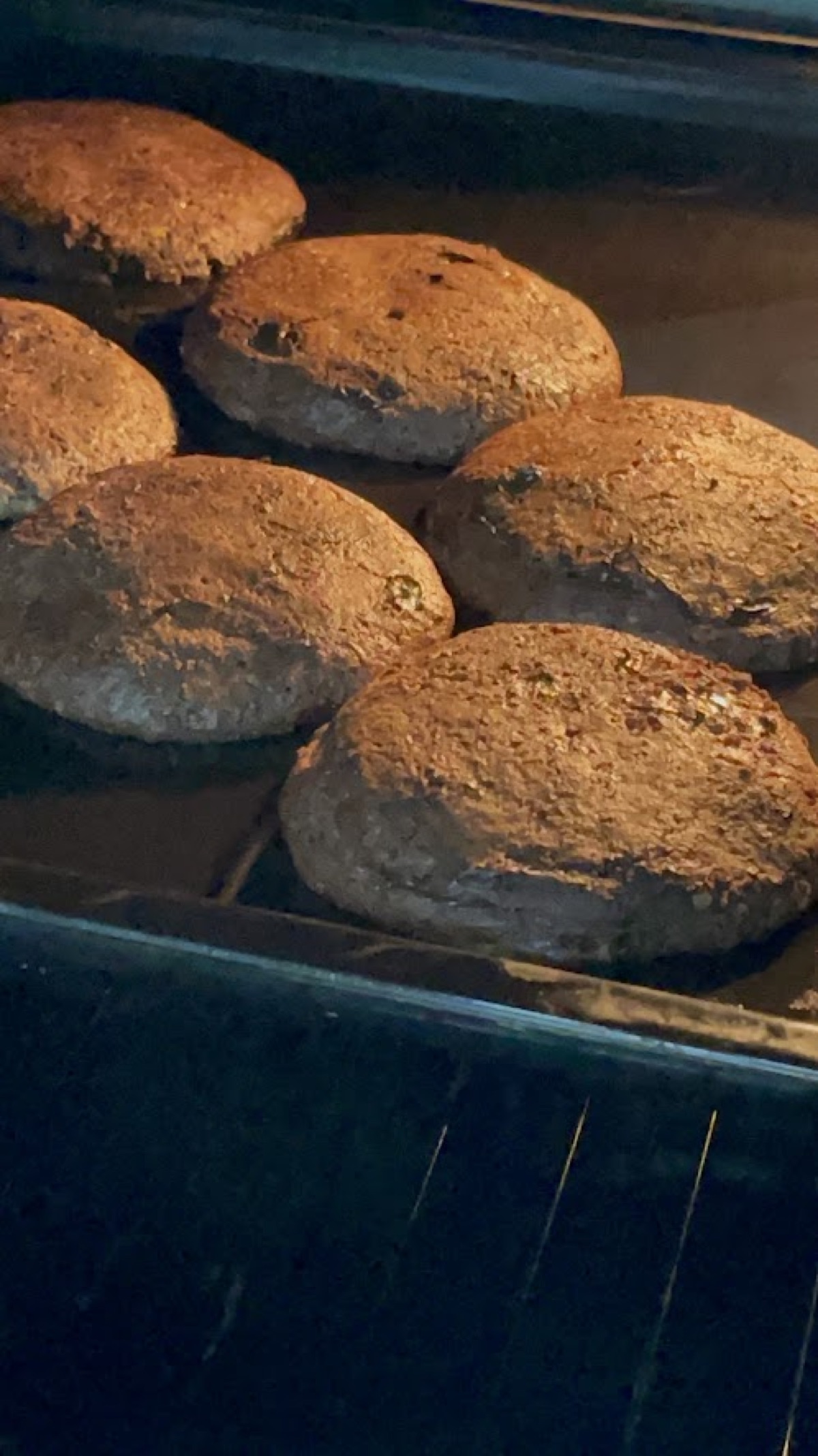 A tray of round bakes browning inside the oven