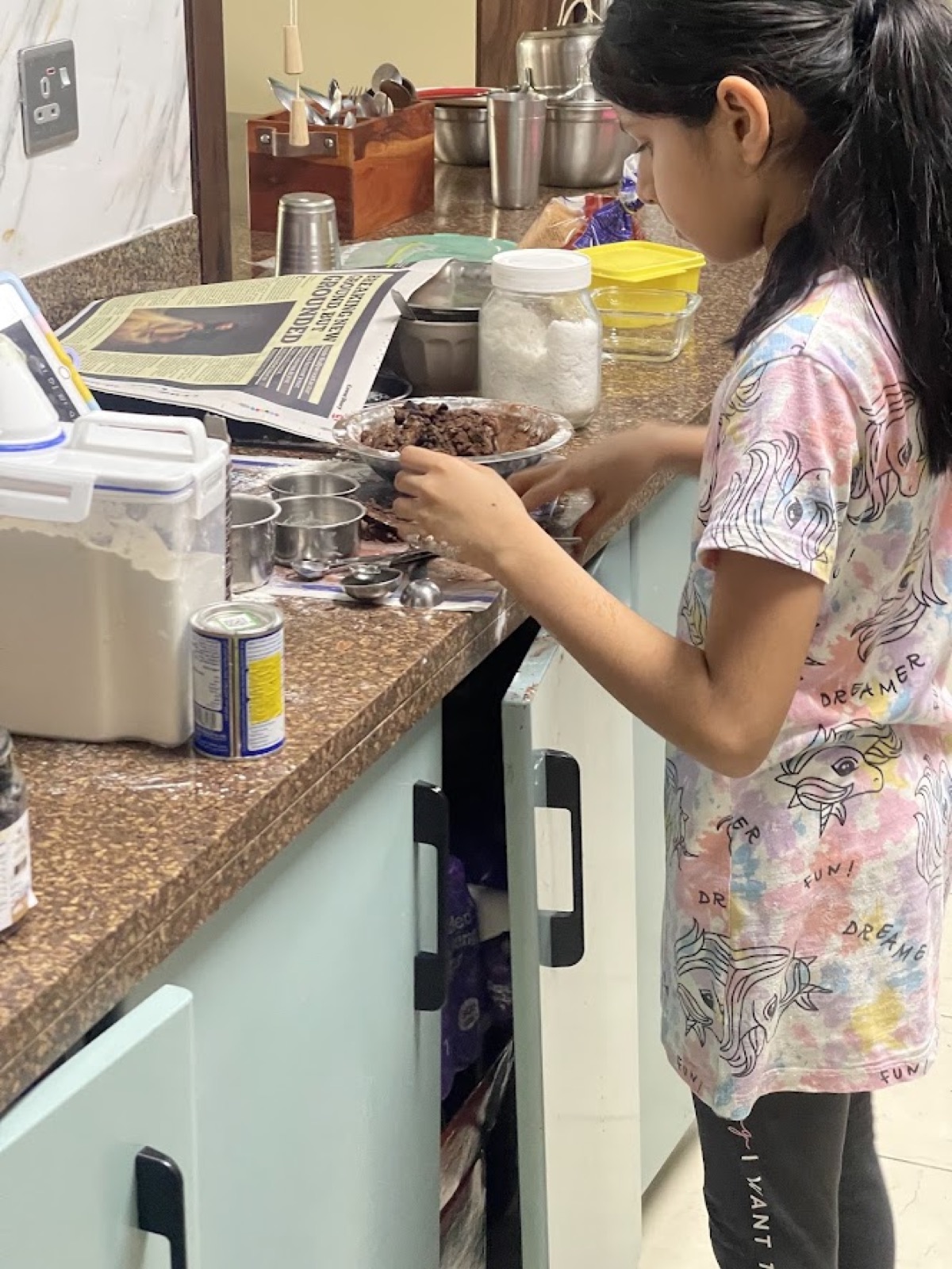 Vedhica measuring and mixing ingredients at the kitchen counter