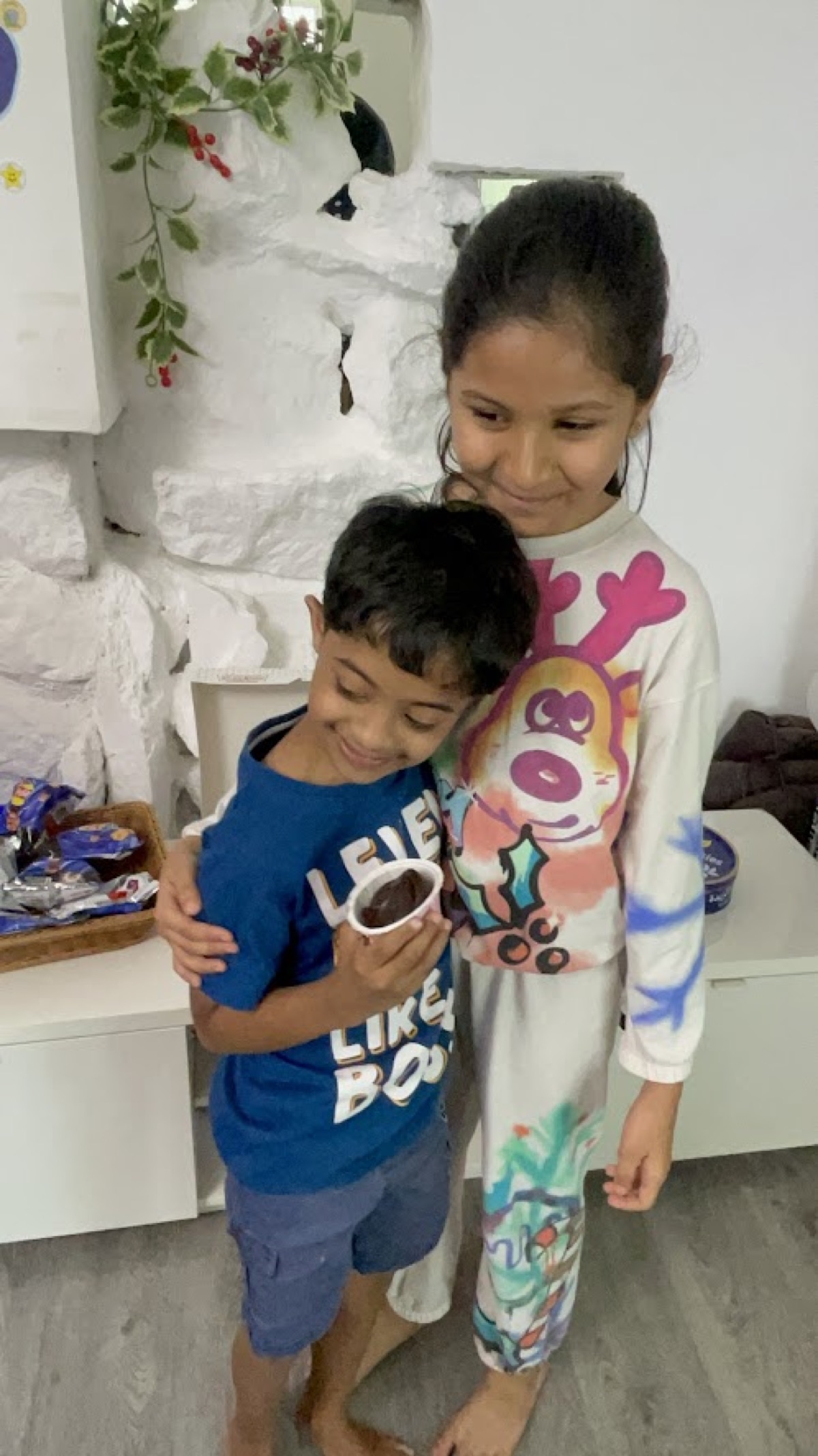 Vedhica handing a cupcake to a younger child